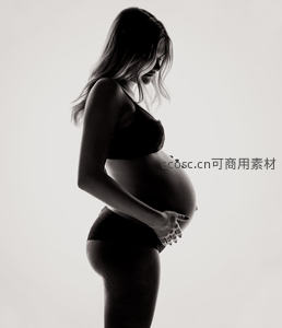 黑白光影下孕妈侧身凝视腹部