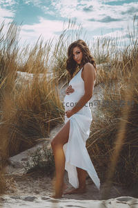 沙滩上的准妈妈温柔凝视镜头