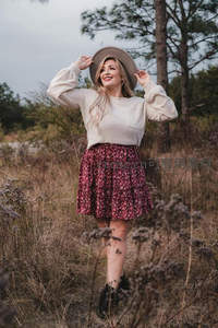 林间草地上戴帽微笑的少女