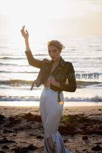 夕阳海边皮衣女郎优雅举手