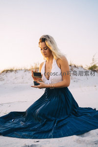 沙滩女子手持首饰盒沉思