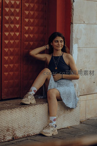 红门前少女倚坐台阶展现街头时尚