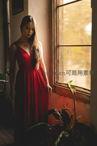 窗边红裙女子沉思