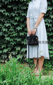 蓝白条纹连衣裙搭配黑色手提包的优雅造型