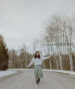 雪路中央的女子张开双臂