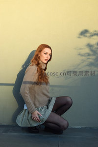 红发少女墙边优雅蹲姿光影写真