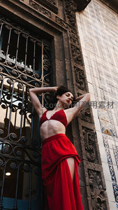 红裙女子倚古建筑门廊