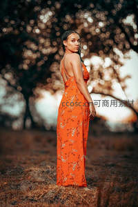 橙色长裙女子回眸林中剪影