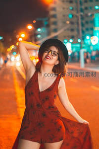 夜街霓虹下红裙女子欢笑起舞