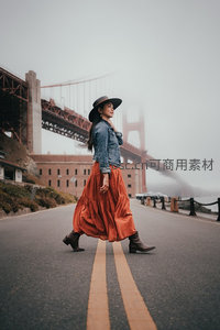 雾中金门桥畔漫步的时尚女子