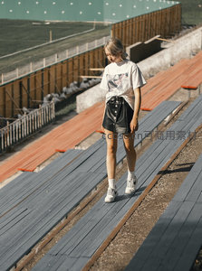 少女漫步于空旷看台，阳光洒落静谧时光