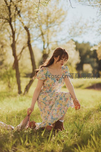 花裙女子草地上采花享受春光