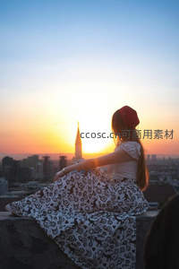 女孩屋顶看日落城市剪影
