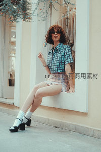 窗边俏皮女郎手持彩虹棒棒糖