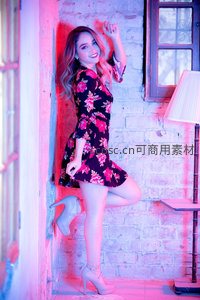 霓虹灯下花裙美女俏皮倚墙摆拍