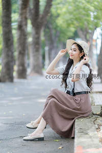 林荫道上优雅坐姿的都市丽人