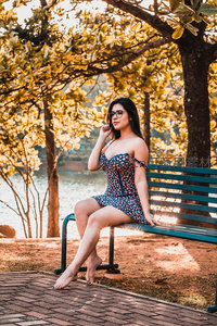 公园长椅上的花裙女子沐浴秋日暖阳