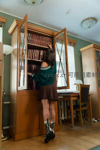 少女在复古书房中挑选书籍