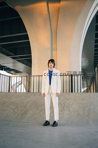 白衣青年立于现代建筑拱廊下