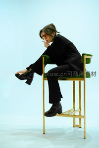 时尚女性坐高脚椅戴墨镜摆酷造型