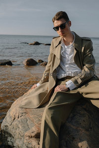 岩石上男士风衣静享海景