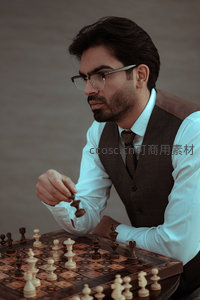 戴眼镜的绅士专注下国际象棋