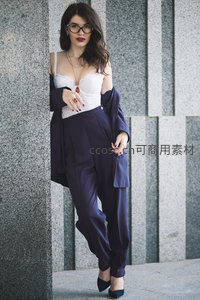 时尚女性倚墙展现优雅姿态