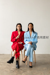 红蓝撞色西装双人坐姿，极简背景时尚秀