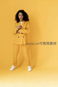 黄色背景中自信站立女模特