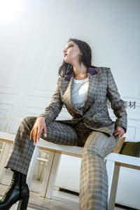格纹西装女郎静坐凝思，优雅姿态彰显知性美