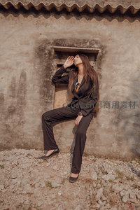 黑西装女子墙边休憩