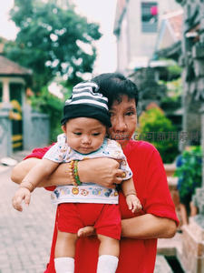 奶奶怀抱婴儿漫步古巷