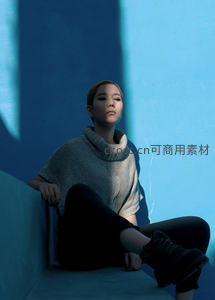 蓝墙角落静坐的短发女子