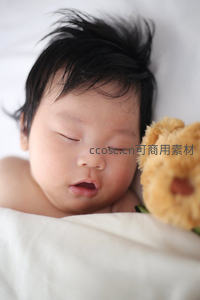 婴儿酣睡，毛绒熊伴梦乡