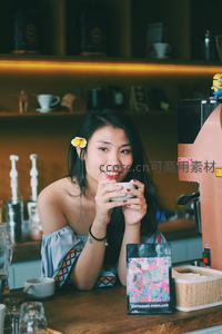 咖啡馆里微笑的女子手捧热饮