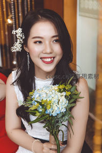 新娘手捧花束微笑，头戴精致发饰