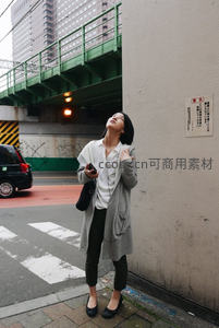 都市街头仰望天空，灰色大衣下的沉思时刻