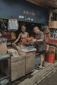 老夫妇在街边杂货店整理货物