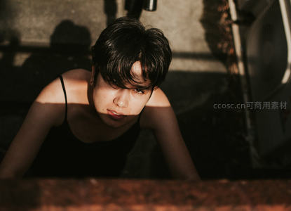 光影交错下女子低头凝视镜头