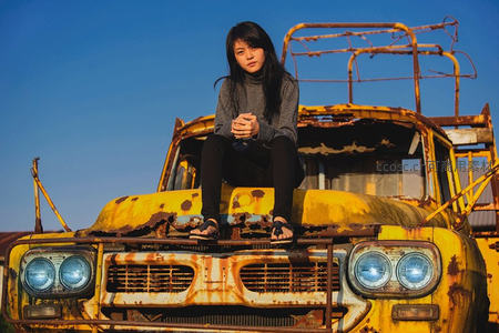 少女坐锈迹斑斑的废弃卡车顶