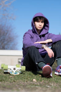 少年穿紫色卫衣草地静坐滑板旁