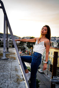 夕阳屋顶少女俯瞰城市街景