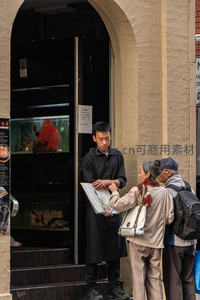 餐厅门口服务员为顾客介绍菜单