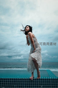 海边泳池边风中起舞的女子