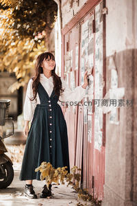 秋日街头女子轻触老墙海报