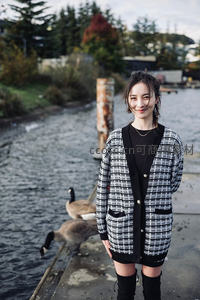 水边微笑女子与野鹅相伴的秋日