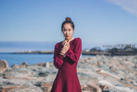 海边岩石上的红裙佳人