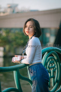 桥边少女持手机回眸