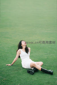 白衣少女躺卧草坪享受午后时光