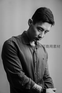 沉思的男子低头凝视手腕上的智能手表